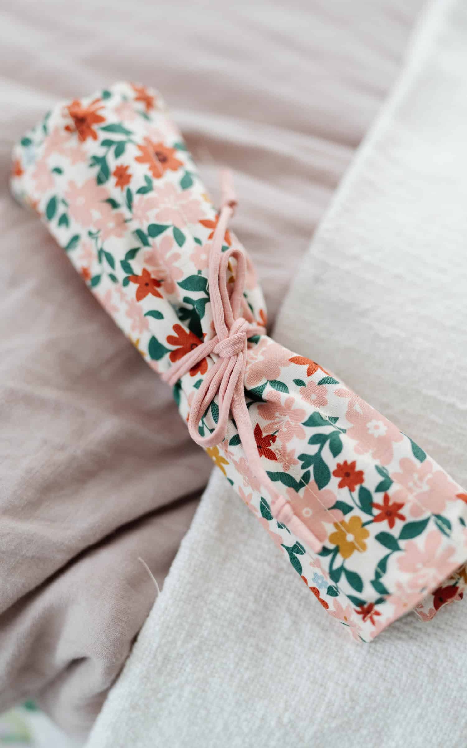 Happy Stitches sewing project supplies for a Crayon Wrap Roll, including fabric pieces, Clover Hot Ruler, Rotary Cutter, Heart-Shaped Pins, Wonder Clips, and Roll & Press